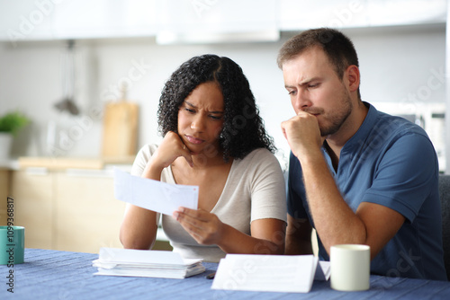Obraz na płótnie Worried interracial couple checking bank statement