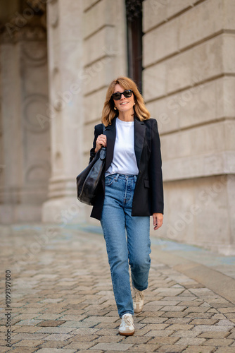 Portrait of a mid adult woman walking in city street and smiling