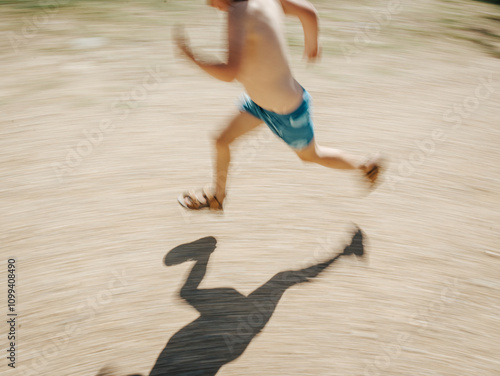 Boy running in swimmers with shadow and motion blur photo