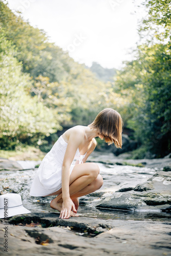 A Graceful Woman is Delightfully Enjoying the Serenity of Nature by the Beautiful Water