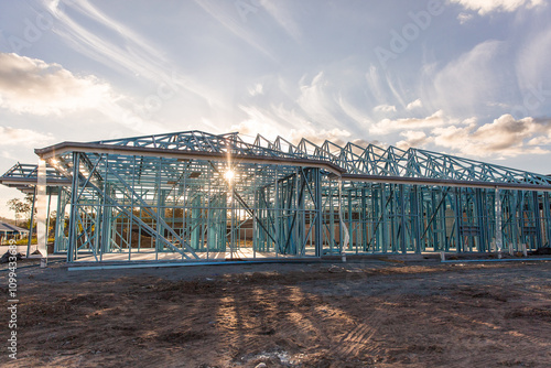 sun shining through the frame of a house being built photo