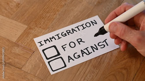 human hand with marker casts support vote on popular trending topic immigration. public opinion varies around outsiders, help, aid and shelter to be offered foreign nationals with refugee status