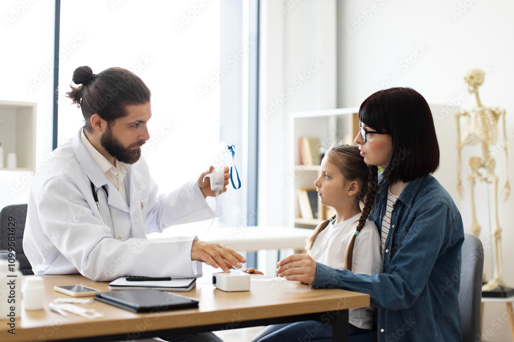 Obraz premium Caucasian female child receiving nebulizer treatment from Caucasian male doctor at clinic. Mother supports daughter during medical consultation.