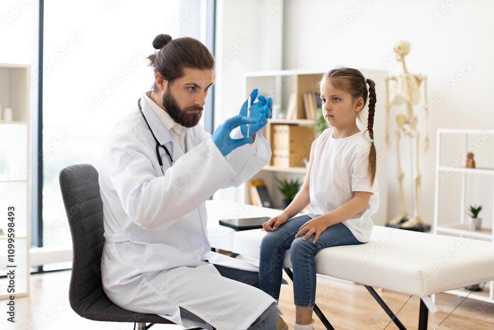 Fototapeta premium Doctor prepares syringe for vaccination while young Caucasian girl sits on medical couch. Scene conveys medical care and trust in healthcare setting.