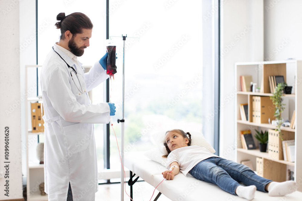 Naklejka premium Male doctor providing blood transfusion to young girl lying on hospital bed. Medical professional wearing white coat, standing next to girl who appears calm.