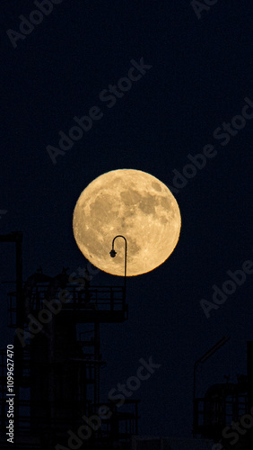 Full moon shining over silhouette of industrial structures photo