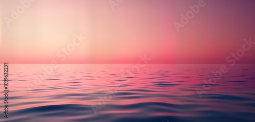 Calm water surface reflects sunset colors. Soft gradient hues of pink, purple blend seamlessly across horizon. Gentle waves create subtle motion in still water. Peaceful scene evokes sense of