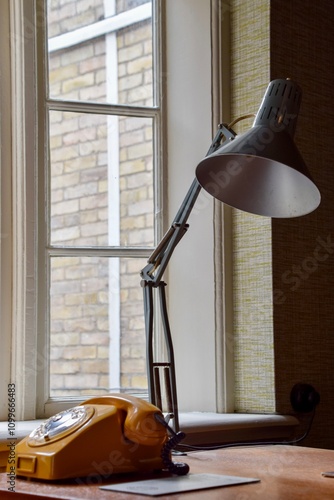 Old yellow telephone with lamp on desk