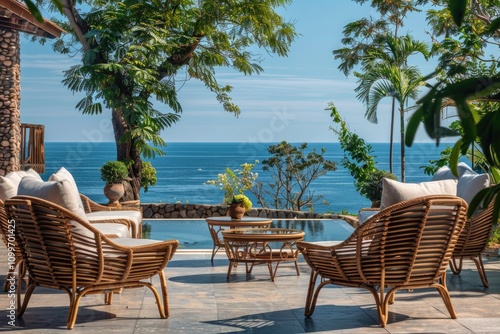 Relaxing rattan chairs on patio overlooking ocean, sunny day. photo