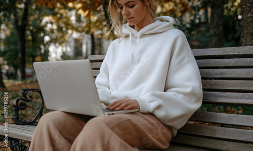 Woman working on laptop in autumn park