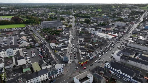 Longford Town, County Longford, Ireland, September 2024. Drone slowly descends over a intersection on Main Street with homes and buildings and St Mel's Cathedral in the distance photo