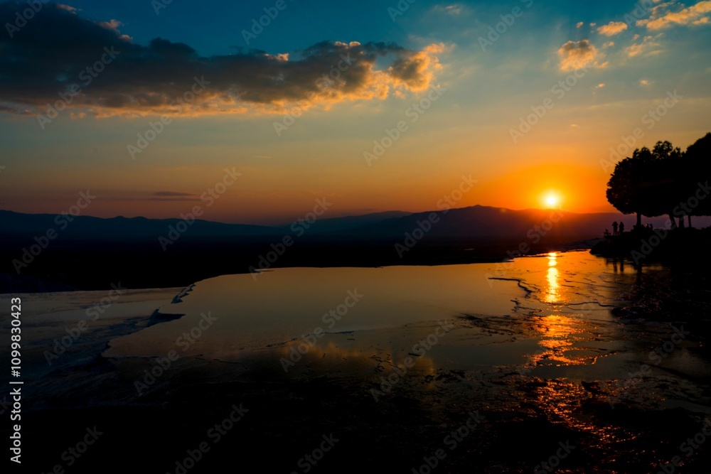 Obraz premium Sunset Silhouettes by the Water