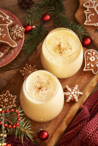 Two glasses of homemade eggnog with gingerbread Christmas cookies and spruce branches photo