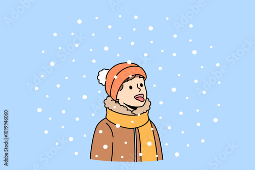 Boy opens mouth and eating snow, enjoying winter weather and new year mood. Christmas portrait of small child in scarf and warm hat, rejoicing with first snow or onset of winter holidays