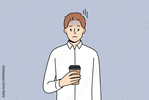 Tired business man suffering from exhaustion and burnout and holding paper cup of coffee in hands. Problems exhaustion among office employee experiencing health difficulties due to constant overtime