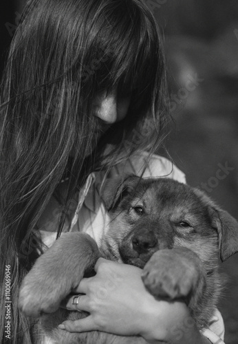 A girl in a village with a puppy in her arms