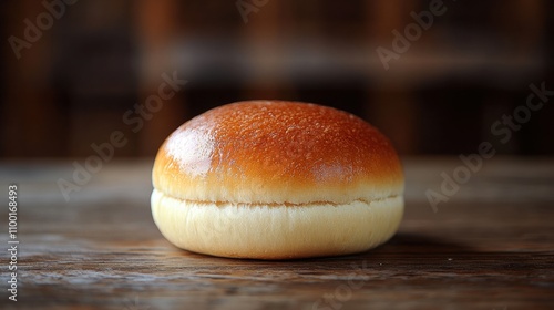 A perfectly baked, golden-brown hamburger bun resting on a rustic wooden surface, showcasing its smooth and fluffy texture in natural light