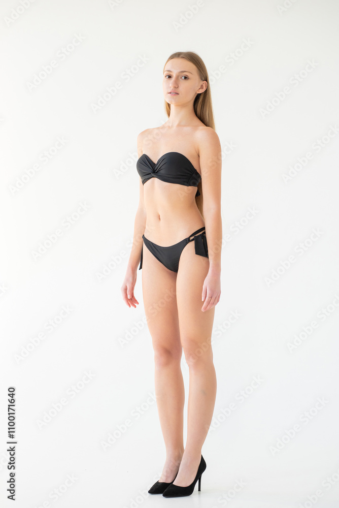 Fototapeta premium young woman in black lingerie and underwear posing on grey background. model agency test shoot