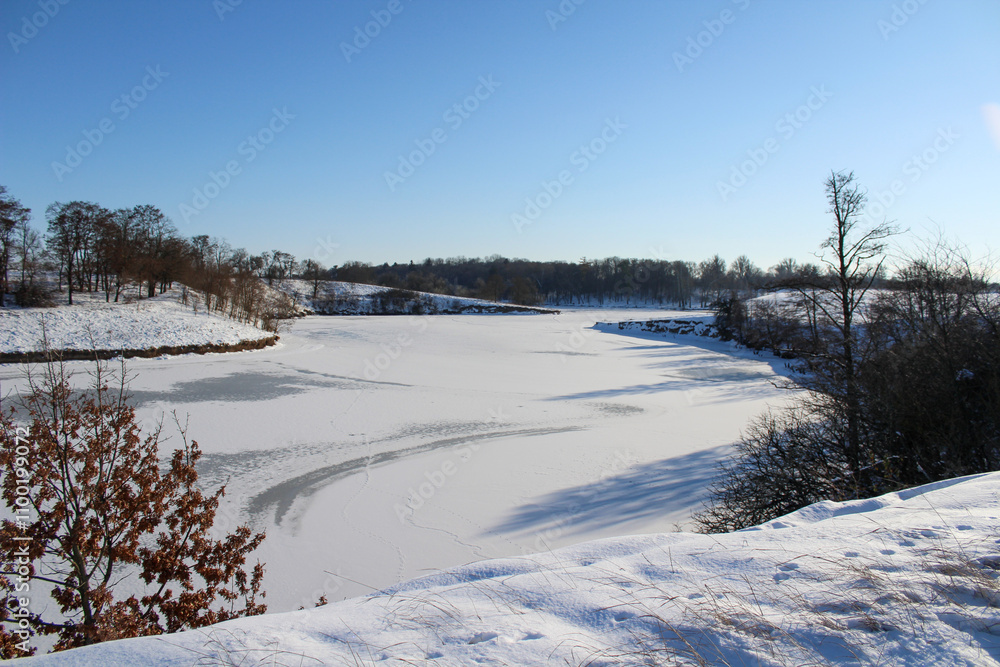 winter landscape overlooking a frozen lake winter landscape overlooking a frozen lake
