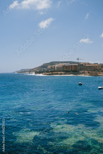 Aerial panoramic beach view of Marsalforn Bay on a sunny day. Scenic viewpoint over Mediterranean Sea. Gozo island. Malta.