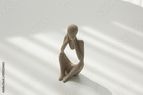 Stone figurine of a sitting and thinking man