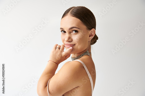 A young woman showcases her charm and style in an elegant dress, embodying beauty and diversity. photo