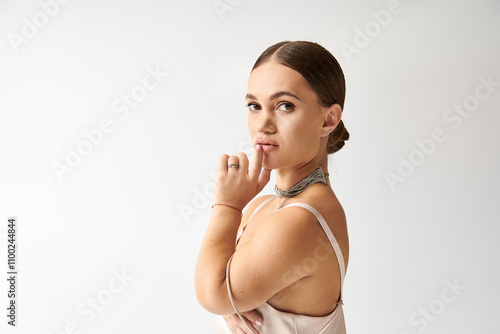 A young woman with short stature poses confidently in a stylish dress, embodying diversity. photo