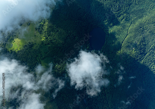 Aerial view of lush green forest and majestic mountains under a beautiful cloudscape, Lautenbachzell, France. photo