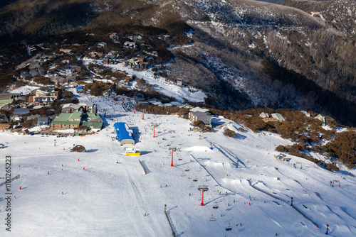 Aerial view of snow-covered Mount Buller ski resort with beautiful alpine landscape and clear blue sky, Victoria, Australia. photo