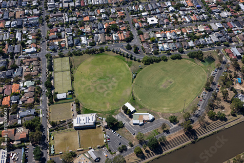 Aerial view of suburban homes and green spaces surrounding a sports field and river, Maribyrnong, Australia. photo