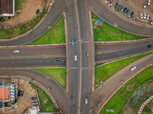 Aerial view of busy highway intersection with vehicles and modern architecture surrounded by greenery, Kaduna North, Nigeria. photo