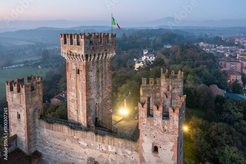 Aerial view of scaligero castle and italian flag in a beautiful sunset over the medieval town of Valeggio sul Mincio, Verona, Italy. photo