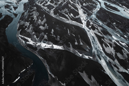 Aerial view of a majestic and serene winter landscape featuring a frozen river and rocky terrain, Vik i Myrdal, Iceland. photo