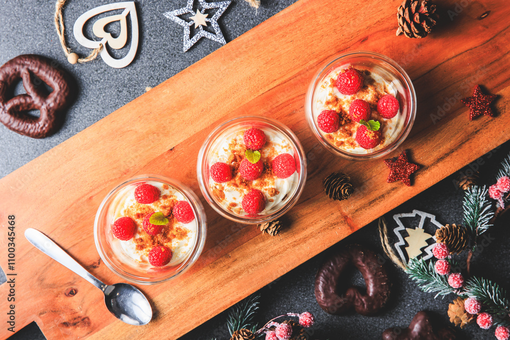Verrine of crushed speculoos, mascarpone and raspberries on a gray background decorated for Christmas