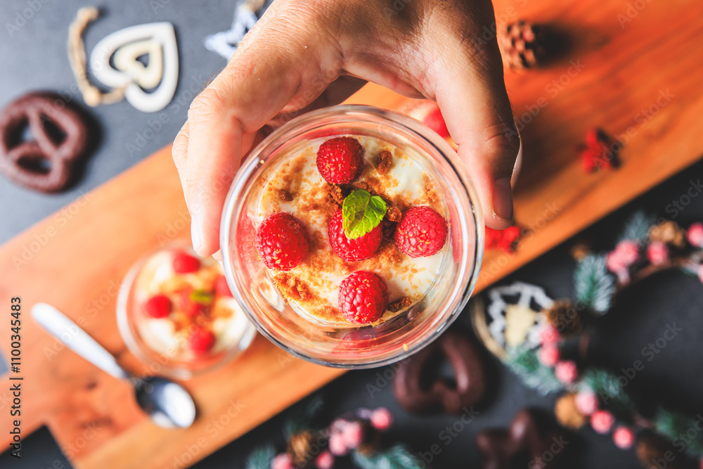 Verrine of crushed speculoos, mascarpone and raspberries on a gray background decorated for Christmas