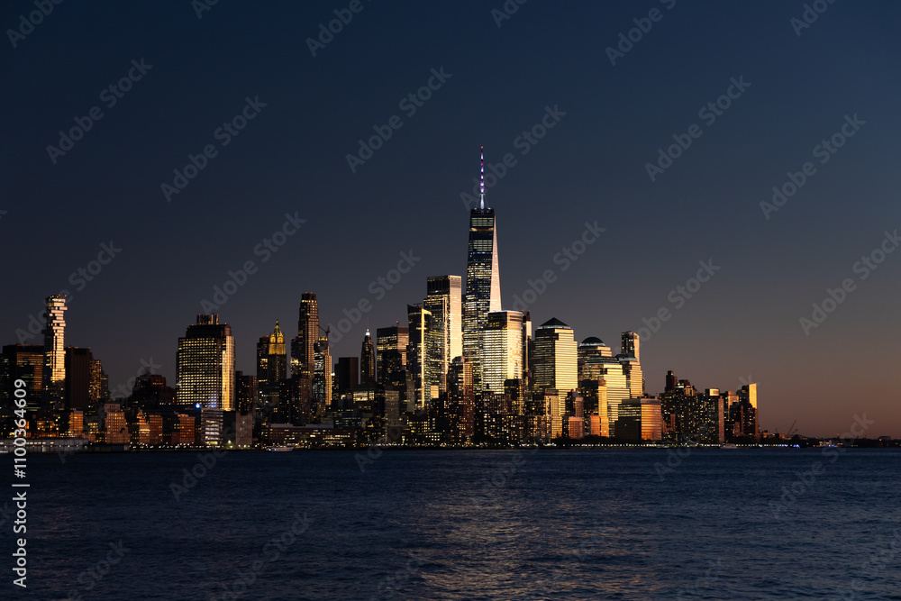 Obraz premium Stunning skyline view of New York City at dusk by the river.