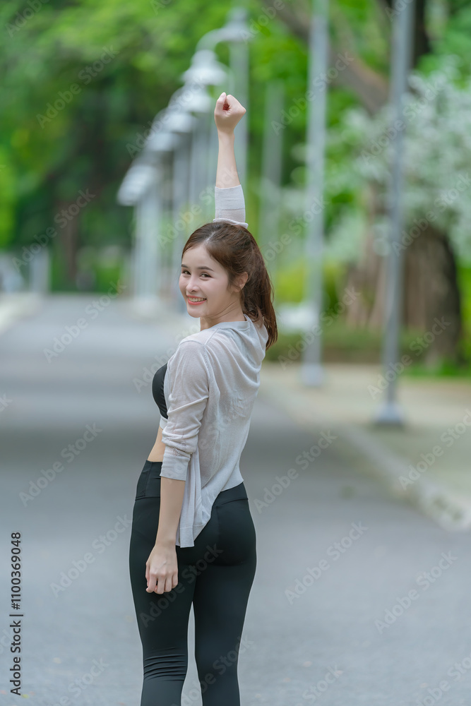 Fototapeta premium Smiling Asian woman doing sport exercises running jogging in morning park, skinny fit in sports wear outfit leggings. fitness woman running around in the park.