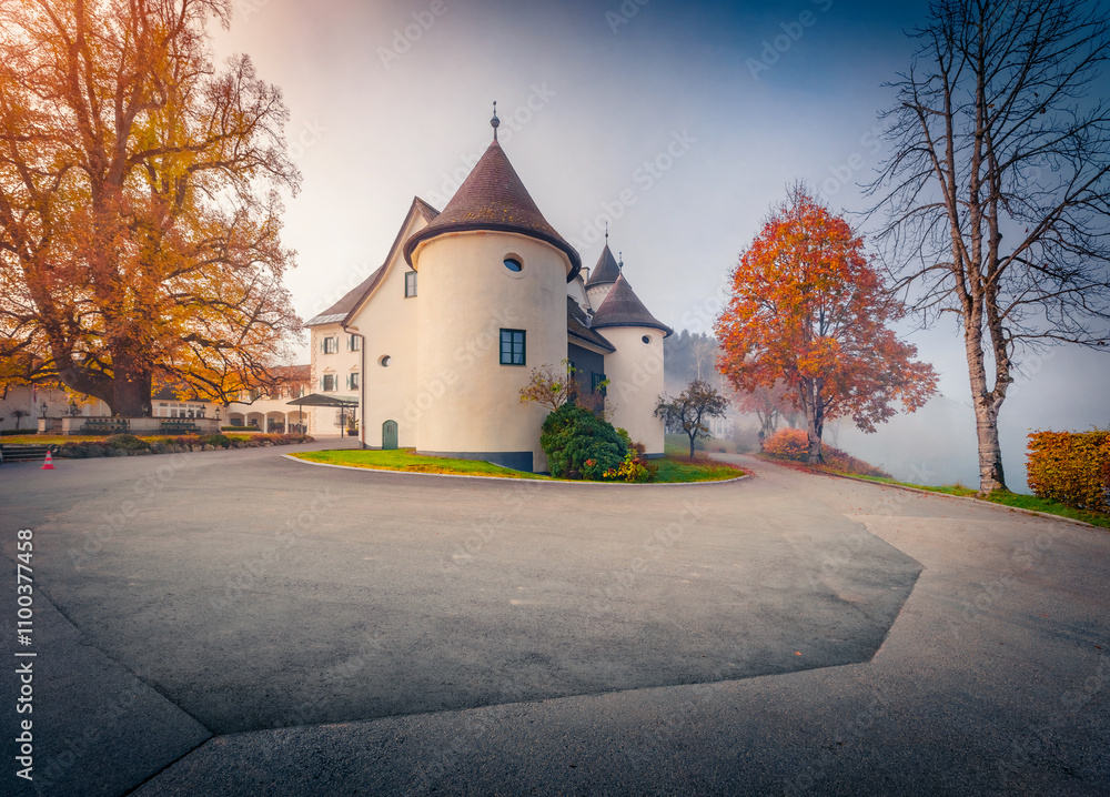Foggy morning view of Pichlarn Castle, situated on an elevation in the Ennstal valley in Styria, at the foot of the Grimming mountain massif. Fabulous autumn cityscape of Pichlarn resort, Austria.