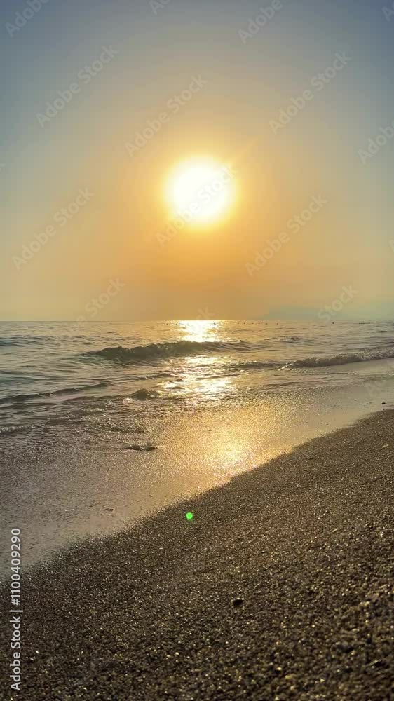 Sunset in Turkey, Alanya. The waves of the Mediterranean Sea roll over the sandy beach. The sunset is reflected in the water and slightly illuminates the city, against the background of Castle Hill.4К Sunset in Turkey, Alanya. The waves of the Mediterranean Sea roll over the sandy beach. The sunset is reflected in the water and slightly illuminates the city, against the background of Castle Hill.4К