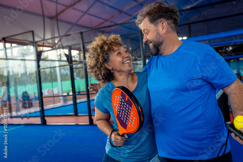 Mixed adult couple celebrate winning the point in padel on outdoor court. photo