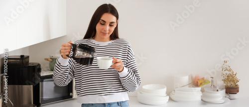 Young woman pouring coffee ...