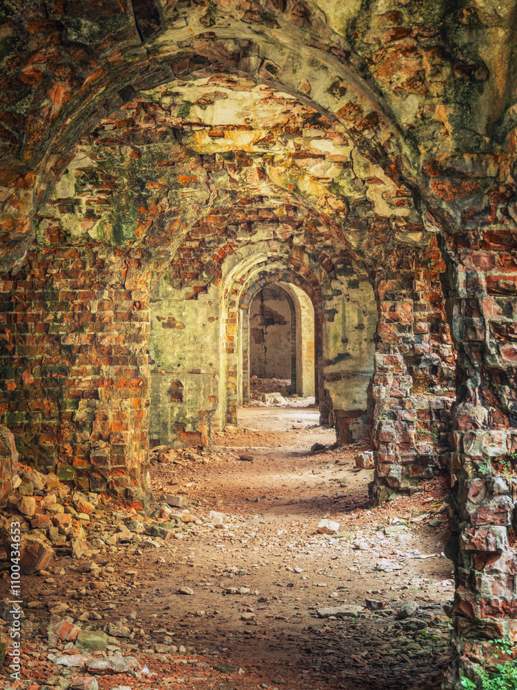 Fototapeta premium portrait view to brick arcs in corridors of old ruined fortress