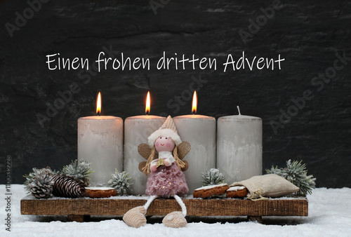 Dritter Advent: Graue Adventskerzen mit Engel und Tannenzweigen im Schnee. Einen frohen dritten Advent. photo