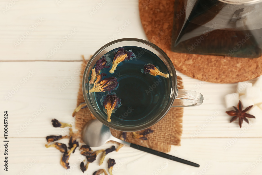 Cup with butterfly pea flower tea and dried flowers on white wooden background, closeup Cup with butterfly pea flower tea and dried flowers on white wooden background, closeup