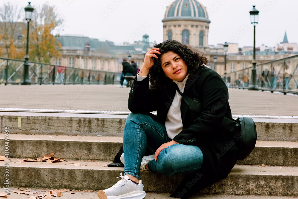 Fototapeta premium Mujer latina sonriendo sentada por las calles de Paris
