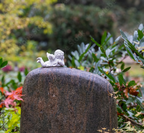 Grabstein mit Skulptur auf einem Friedhof

