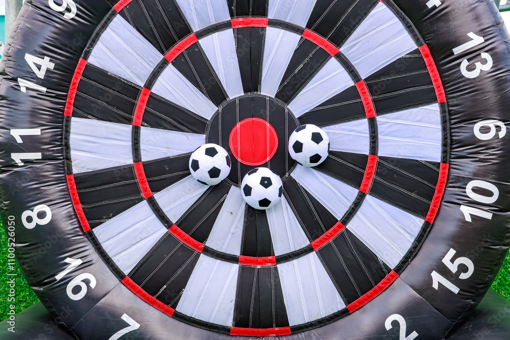 A large inflatable soccer ball with a red and white bullseye and a black
