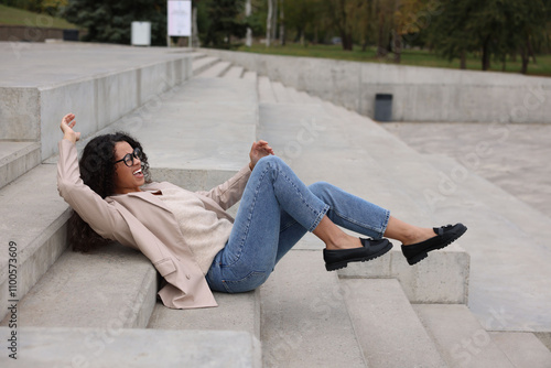 Injured woman on stairs outdoors after fall. Dangerous accident photo