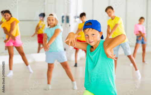 Boy and other kids dancing hip hop in dance studio photo