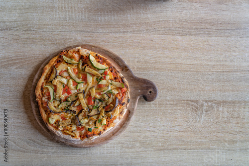 reshly made pizza, the vibrant red tomatoes and fresh basil peeking through the melted cheese on a wooden table and copy space photo